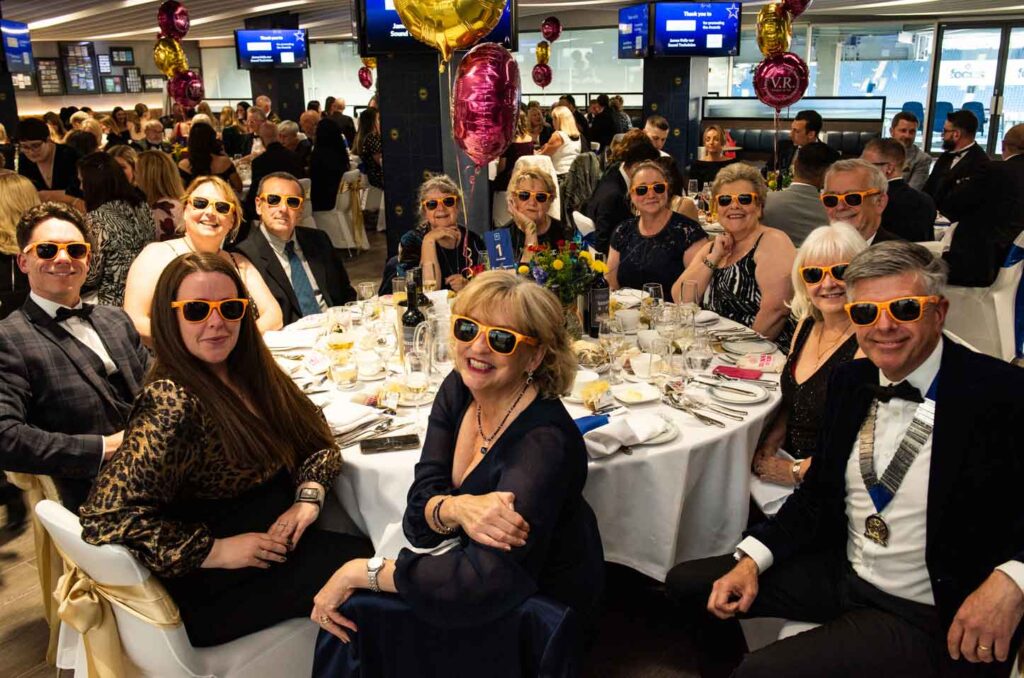 people wearing sunglasses around a round table