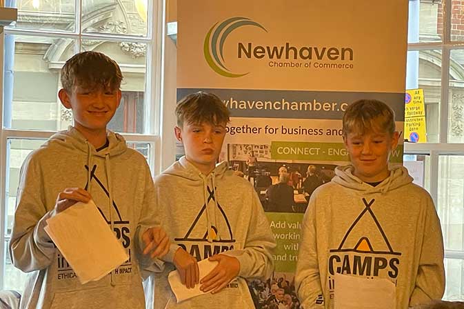 Three teenage boys in Camp Kenya sweatshirts.